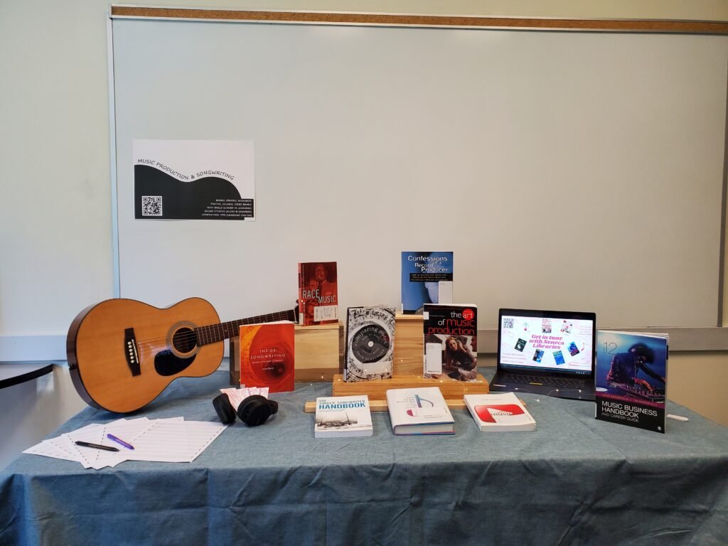 Table display of music instrument and books for music production and songwriting students at Seneca Library